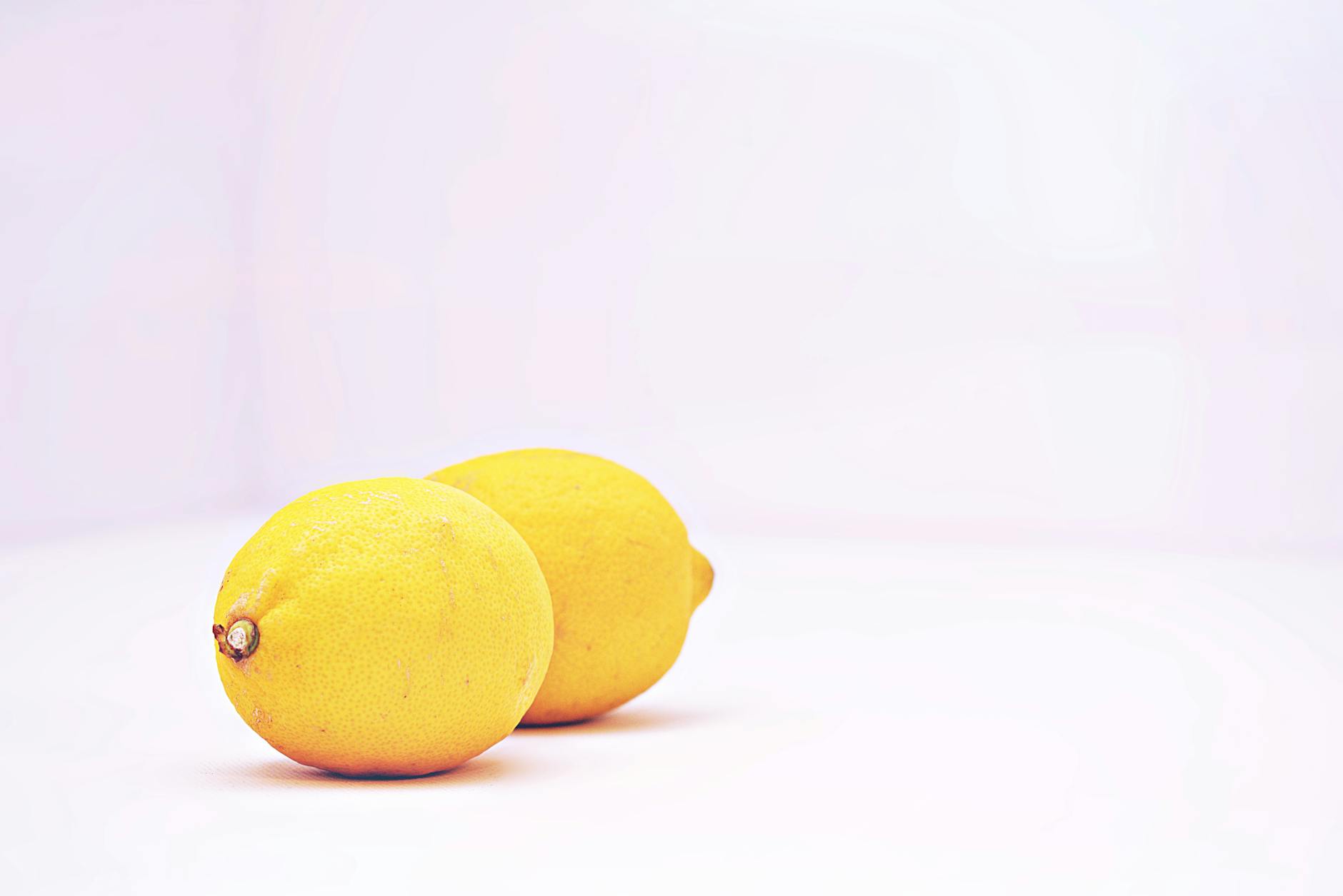 Two fresh lemons on a white background symbolizing clarity and pressure relief