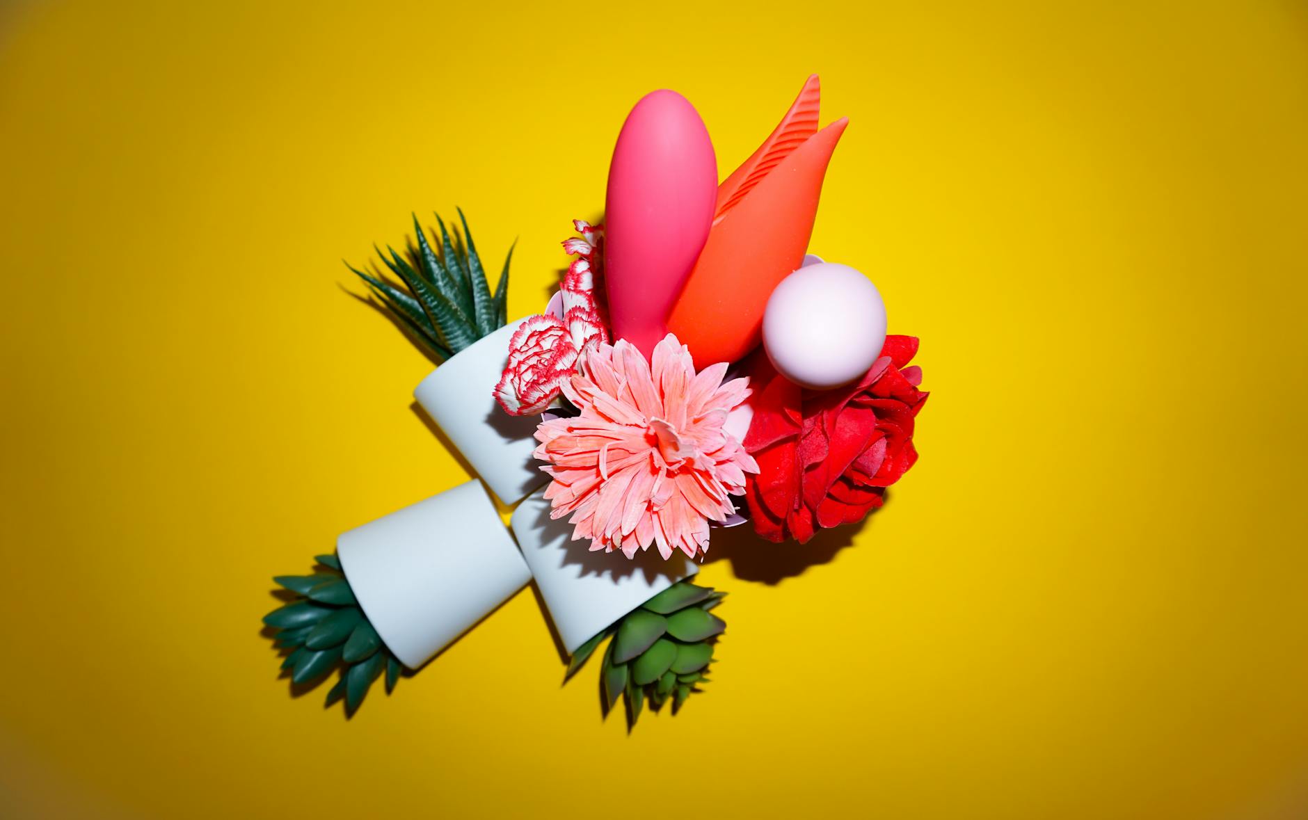 Colorful clitoral vibrators arranged on a bright yellow background