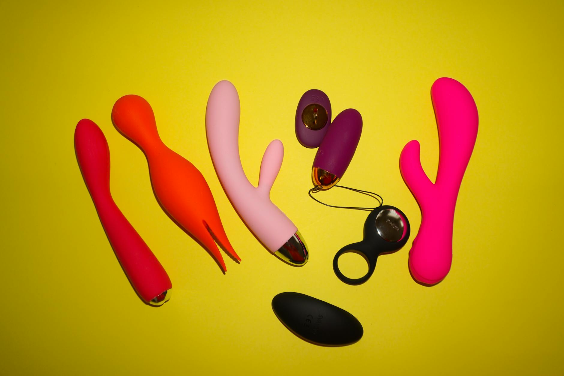 Collection of colorful clitoral vibrators on a bright yellow background